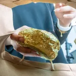 A woman taking a packaged burger out of a bag